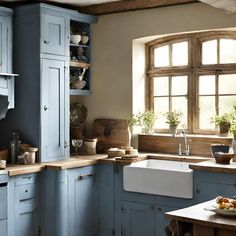 a kitchen filled with lots of blue cabinets and counter top space next to a window