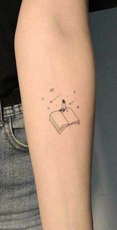 a person with a book tattoo on their arm