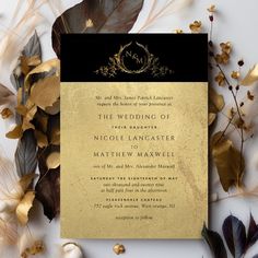 a black and gold wedding card with leaves