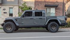 a gray jeep parked in front of a brick building