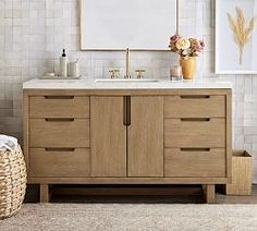 a bathroom vanity with two sinks and a mirror on the wall above it, next to a wicker basket