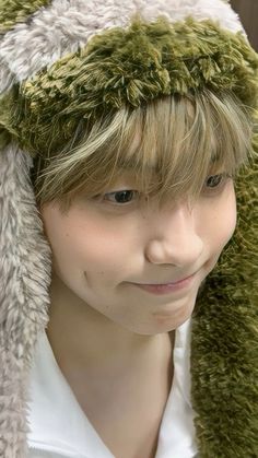 a young man wearing a furry animal hat