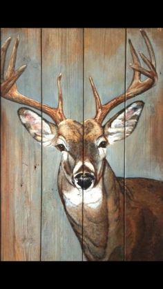 a painting of a deer with antlers on it's head is painted on wood