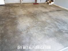 an empty garage with concrete floors and tools on the ground in front of it,