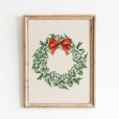 a painting of a wreath with red bow hanging on the wall next to a white wall