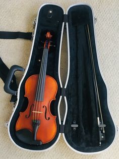 the violin is in its case on the floor next to it's straps