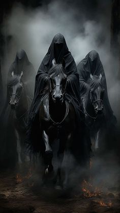 three black horses with hooded riders in the fog