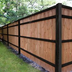 a wooden fence in the middle of a grassy area