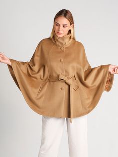 So soft - you'll want to keep it on all day. Our Clara cape is the definition of timeless. With its classic belted cape silhouette, it will never go out of style. Expertly crafted in baby alpaca and wool for an exquisite finish that will stand the test of time. A wonderful gift idea for yourself or someone special. Product Details: Belted Cape with Rib-knit Collar 70% Baby Alpaca / 30% Wool High Neckline Lined, with Pockets Below Hip Length Fastens with 4 buttons (+1 Spare). Press Studs at Sides Luxury Oversized Beige Poncho, Luxury Beige Poncho For Fall, Luxury Beige Cape For Spring, Luxury Chic Beige Cape, Luxury Solid Color Cape For Fall, Luxury Traditional Cape-style Outerwear, Luxury Traditional Cape Outerwear, Cheap Fall Cape Poncho, Luxury Cape Poncho