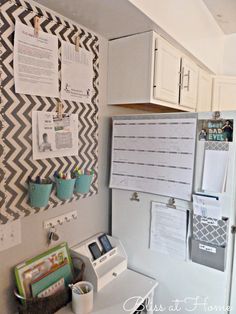 a white refrigerator freezer sitting inside of a kitchen next to a wall mounted bulletin board