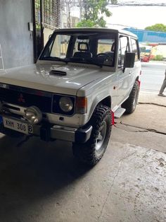 a silver and black jeep parked in front of a building