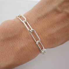 "SOLID 925 STERLING SILVER This unique bracelet is hand-crafted out of solid sterling silver and features a thick and chunky \"paperclip\" style chain. The rectangle links measure approximately 15mm long and 6mm wide. Bracelet is available in your choice of length and closes with an easy-to-use lobster claw clasp. Comes in a gift box. More paperclip bracelets available here: www.etsy.com/shop/TheVioletGoat?ref=seller-platform-mcnav&search_query=paperclip+bracelet SIZING - IMPORTANT: To determine bracelet size, measure snugly around the wrist and add 1 inch. Because this chain has large links, it can be clipped anywhere for an adjustable fit. If you're unsure of size, I recommend sizing up. RETURNS/EXCHANGES: Due to the high cost of materials for this bracelet, I'm unable to accept returns Luxury Rectangular Sterling Silver Chain Bracelet, Everyday Sterling Silver Bracelet With Chunky Chain, Sterling Silver Bracelets With Chunky Chain In Oval Link, Sterling Silver Link Bracelets With Paperclip Chain, Sterling Silver Bracelets With Paperclip Chain, Silver Chain Bracelet With Paperclip Link, Silver Chunky Chain Link Paperclip Bracelet, Silver Paperclip Bracelet With Chunky Oval Link, Silver Link Paperclip Bracelet With Chunky Chain