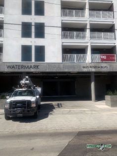 a truck parked in front of a tall building