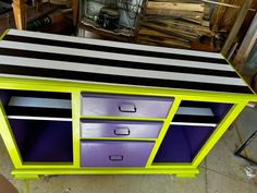 a purple and black striped dresser with drawers