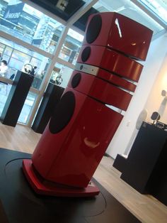 a large red object with black dots on it's sides in front of a store window