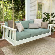 a porch swing with pillows on it