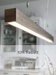 a wooden light fixture hanging from the ceiling in a room with white walls and cabinets