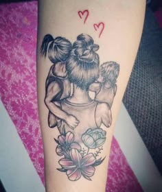 a tattoo with two girls hugging each other on the arm, and hearts above them