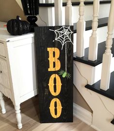 a wooden sign that says boo boo on it next to some stairs and a white cabinet