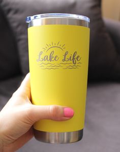 a person holding a yellow cup with the words lake life on it