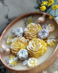 some yellow and white flowers in a bowl