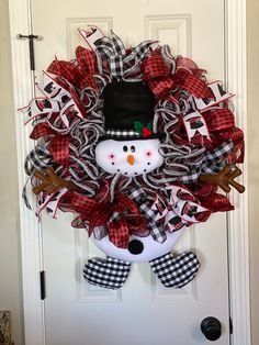 a snowman wreath hanging on the front door