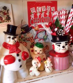 there are many snowmen on the shelf with candy canes in their mouths and hats