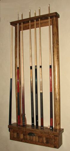 an old wooden rack with pool cues in it