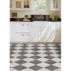 a black and white checkered floor in a kitchen with cabinets, counter tops, and sink