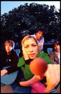 a group of people sitting around each other with a ball in front of their face