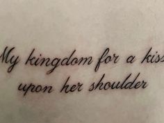 a tattoo with the words my kingdom for a kiss upon her shoulder is shown in black ink