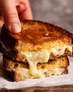 a grilled cheese sandwich is being held up