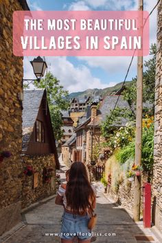 a woman walking down an alley way with the words, the most beautiful villages in spain