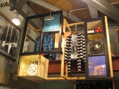 an open display case with clothes hanging from it's sides and other items on the shelves