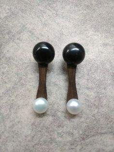 two black and white knobs with pearls on the top one is turned upside down