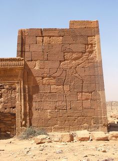 an ancient building in the desert with no people around it and only one person standing outside