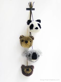 three crocheted panda bears hanging on a wall with a cross in the background