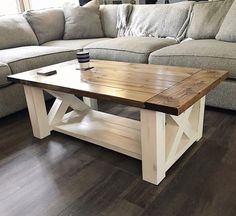 a wooden table sitting in front of a couch on top of a hard wood floor