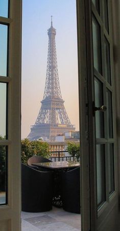 the eiffel tower is seen through an open door in front of a balcony