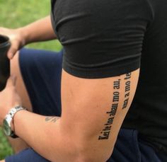 a man with a tattoo on his arm holding a coffee cup