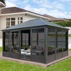 a gazebo sitting on top of a lush green field next to a swimming pool