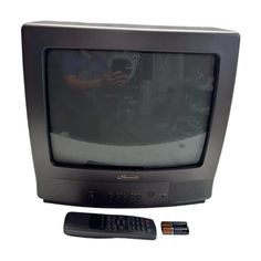 an old television and remote control sitting next to each other in front of a white background