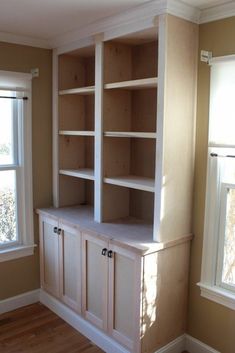 an empty room with some shelves and windows