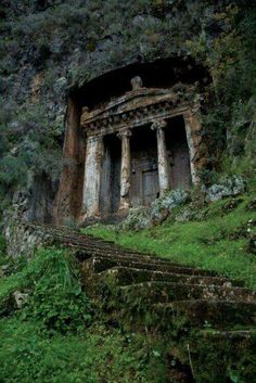 an old building with steps leading up to it in the middle of a mountain side