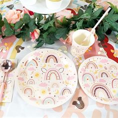 a table set with plates, cups and utensils for a unicorn themed birthday party