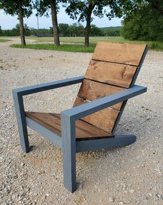 a wooden chair sitting on top of a gravel field