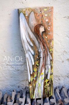 an angel painted on the side of a wall next to some rocks and cement blocks