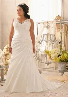 a woman in a white wedding dress posing for the camera