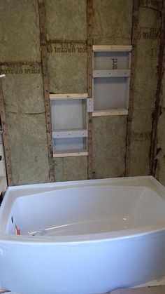 a bath tub sitting in the middle of a room with construction materials on the walls