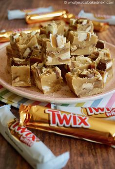 a plate filled with pieces of fudge next to some candy bars on a table